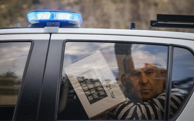 A protester wearing a mask depicting Prime Minister Benjamin Netanyahu and wearing a prisoner's uniform is detained during a demonstration on November 14, 2020 (Yonatan Sindel/Flash90) A protester wearing a mask depicting Prime Minister Benjamin Netanyahu and wearing a prisoner's uniform is detained during a demonstration on November 14, 2020 (Yonatan Sindel/Flash90)