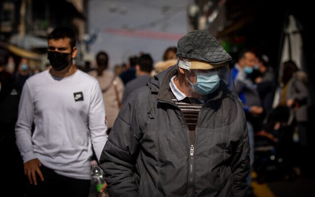 People wearing face masks shop at the Mahane Yehuda market in Jerusalem on November 27, 2020. (Yonatan Sindel/Flash90) People wearing face masks shop at the Mahane Yehuda market in Jerusalem on November 27, 2020. (Yonatan Sindel/Flash90)
