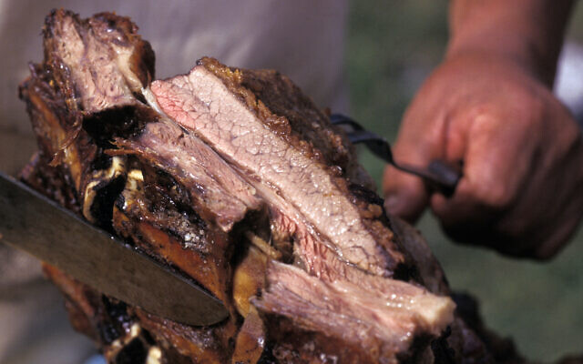 A griller shows a piece of "asado," a traditional Argentine barbecue meat. (Ricardo Ceppi/Getty Images) A griller shows a piece of "asado," a traditional Argentine barbecue meat. (Ricardo Ceppi/Getty Images)