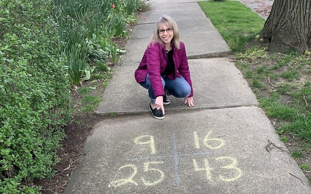 Leslie Frischman poses next to one of her sidewalk equations in this undated photo taken in 2020. (Courtesy) Leslie Frischman poses next to one of her sidewalk equations in this undated photo taken in 2020. (Courtesy)
