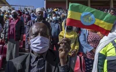 A man holds a national flag as he waits in the stands to give blood at a blood drive in support of the country's military, at a stadium in the capital Addis Ababa, Ethiopia, November 12, 2020. (AP Photo/Mulugeta Ayene)