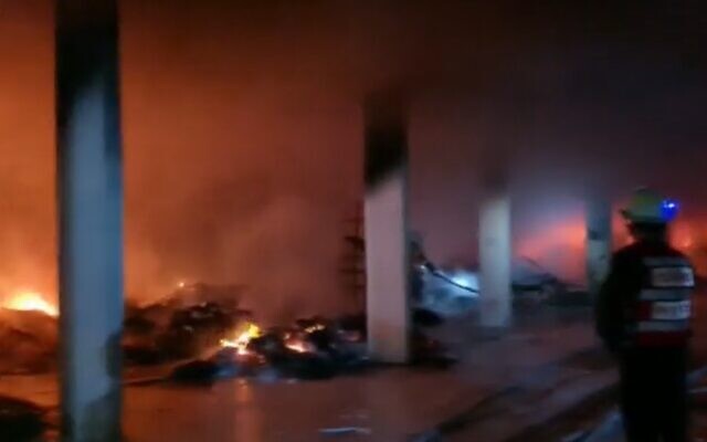 Firefighters work to extinguish a blaze at a residential building complex in the Jerusalem neighborhood of Romema, November 24, 2020 (Screen grab/Channel 12 news)