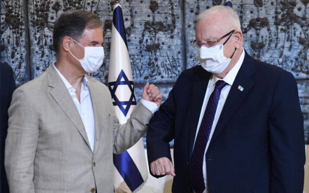 Eytan Stibbe and Israeli president Reuven Rivlin bump elbows at a ceremony celebrating Stibbe's planned trip to the International Space Station, November 16, 2020 (Mark Neyman/GPO) Eytan Stibbe and Israeli president Reuven Rivlin bump elbows at a ceremony celebrating Stibbe's planned trip to the International Space Station, November 16, 2020 (Mark Neyman/GPO)