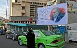 A woman walk by a billboard in honour of slain nuclear scientist Mohsen Fakhrizadeh in the Iranian capital Tehran, on November 30, 2020. (ATTA KENARE/AFP)