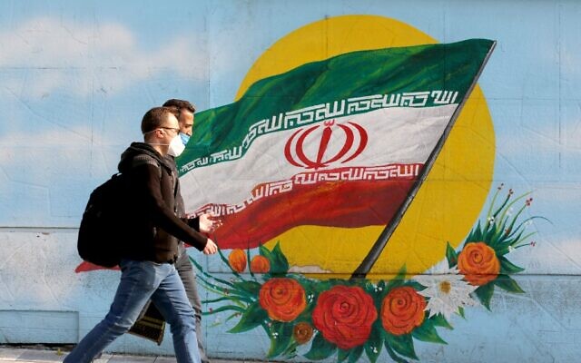 Men walk while wearing face masks amid the COVID-19 pandemic in the Iranian capital Tehran, on November 30, 2020. (ATTA KENARE / AFP) Men walk while wearing face masks amid the COVID-19 pandemic in the Iranian capital Tehran, on November 30, 2020. (ATTA KENARE / AFP)