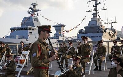 An Israeli military band rehearses ahead of a ceremony marking the arrival of the first of four new German-built Sa'ar 6 ships (back left), at the naval base in Haifa on December 2, 2020. (Heidi Levine/Pool/AFP)