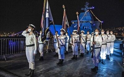 Israeli sailors take part in a ceremony marking the arrival of the first of four new German-built Sa'ar 6 ships (back left), at the naval base in Haifa on December 2, 2020. (Heidi Levine/Pool/AFP)