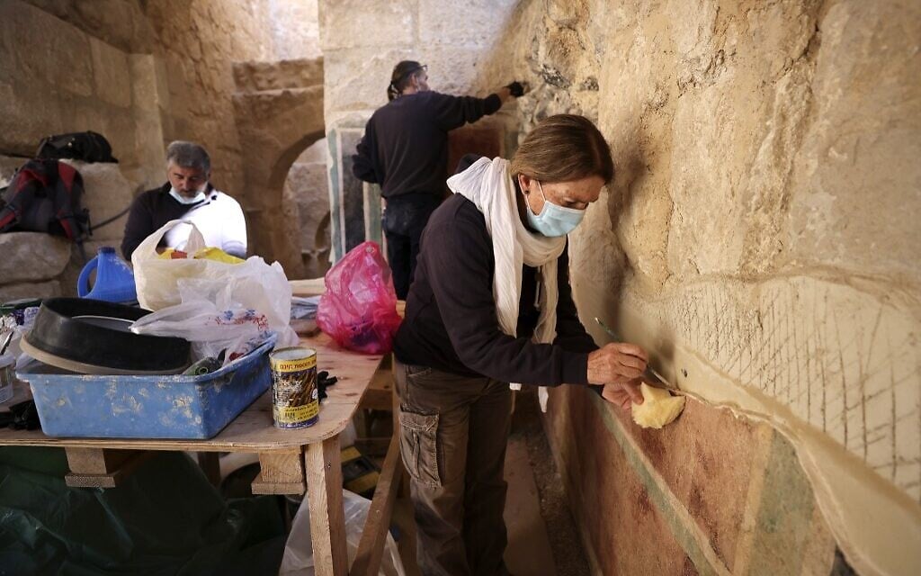 Conservators of the Israel Antiquities Authority restore ancient frescoes at the arches corridor leading to the Herodium palace built by Herod the Great between 23-15 BCE in the Judaean desert, southeast of Bethlehem on November 23, 2020.  (Menahem KAHANA / AFP)