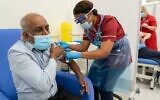 Care home worker Pillay Jagambrun (L), 61, reacts as he receives a dose of the Pfizer/BioNTech COVID-19 vaccine at Croydon University Hospital in south London on December 8, 2020. (Dan CHARITY / POOL / AFP)