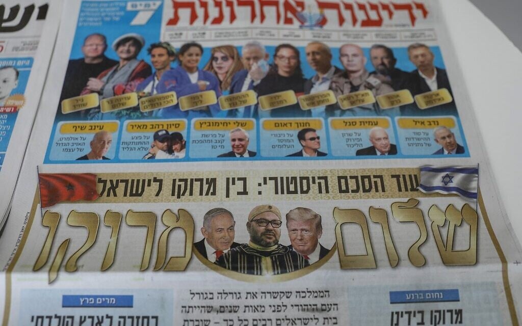 This picture taken on December 11, 2020 in Jerusalem shows Israeli newspapers' front page titles about the announcement that Israel is to establish diplomatic relations with Morocco.(AHMAD GHARABLI / AFP)