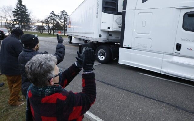 Nancy Galloway (L) and Susan Deur cheer as trucks carrying the first shipment of the COVID-19 vaccine that is being escorted by the US Marshals Service, leave Pfizer's Global Supply facility in Kalamazoo, Michigan, on December 13, 2020. (JEFF KOWALSKY / AFP) Nancy Galloway (L) and Susan Deur cheer as trucks carrying the first shipment of the COVID-19 vaccine that is being escorted by the US Marshals Service, leave Pfizer's Global Supply facility in Kalamazoo, Michigan, on December 13, 2020. (JEFF KOWALSKY / AFP)