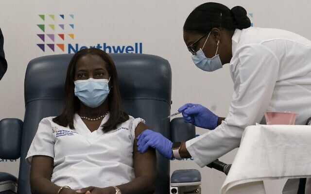 Illustrative: Sandra Lindsay (L), a nurse, is inoculated with the COVID-19 vaccine by Dr. Michelle Chester, at Long Island Jewish Medical Center, on December 14, 2020, in the Queens borough of New York. (Mark Lennihan/Pool/AFP)