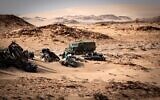 A Moroccan army vehicle drives past car wreckage in Guerguerat, in Western Sahara, on November 24, 2020, after an intervention of the royal Moroccan armed forces in the area. (Fadel Senna/AFP/File)