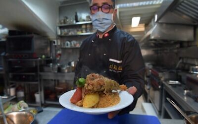 Tunisian chef Taieb Bouhadra presents a prepared traditional Tunisian lamb couscous dish at a restaurant in the Medina (old town) of Tunisia's capital Tunis on December 16, 2020.  (Fethi Belaid / AFP)