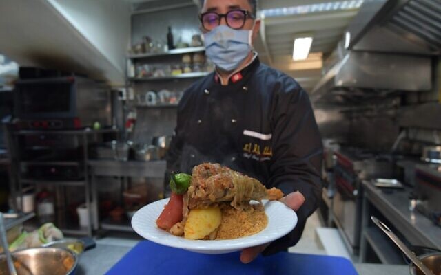 Tunisian chef Taieb Bouhadra presents a prepared traditional Tunisian lamb couscous dish at a restaurant in the Medina (old town) of Tunisia's capital Tunis on December 16, 2020. (Fethi Belaid / AFP) Tunisian chef Taieb Bouhadra presents a prepared traditional Tunisian lamb couscous dish at a restaurant in the Medina (old town) of Tunisia's capital Tunis on December 16, 2020. (Fethi Belaid / AFP)