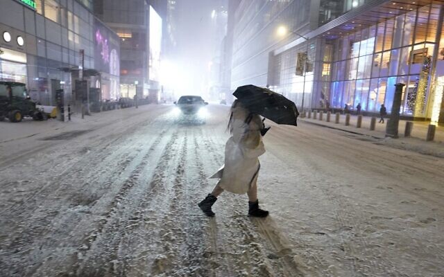 A person holds an umbrella as she walks under the snow in Times Square in New York City, December 16, 2020, as Storm Gail hits the East coast. (Timothy A. Clary/AFP) A person holds an umbrella as she walks under the snow in Times Square in New York City, December 16, 2020, as Storm Gail hits the East coast. (Timothy A. Clary/AFP)