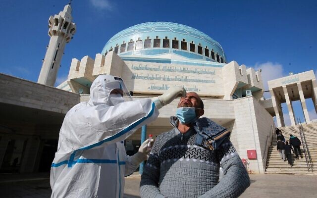 A member of the Jordanian health ministry's epidemiological investigation team takes a random nasal swab to test for coronavirus, from a man leaving the King Abdullah I mosque following the Friday noon prayers, in the capital Amman, on December 18, 2020. (Khalil MAZRAAWI / AFP) A member of the Jordanian health ministry's epidemiological investigation team takes a random nasal swab to test for coronavirus, from a man leaving the King Abdullah I mosque following the Friday noon prayers, in the capital Amman, on December 18, 2020. (Khalil MAZRAAWI / AFP)