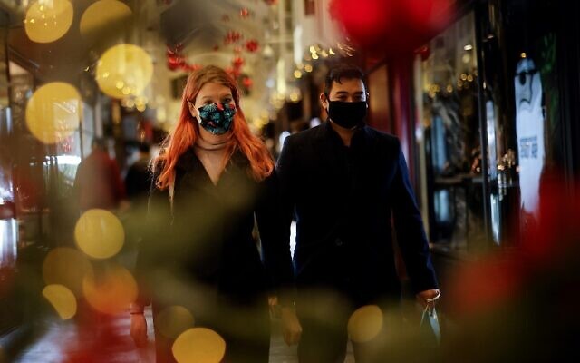 Shoppers, some wearing a face mask or covering due to the COVID-19 pandemic, look at shop window displays inside a christmas-themed Burlington Arcade in London on December 19, 2020. (Tolga Akmen / AFP) Shoppers, some wearing a face mask or covering due to the COVID-19 pandemic, look at shop window displays inside a christmas-themed Burlington Arcade in London on December 19, 2020. (Tolga Akmen / AFP)