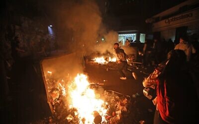 Lebanese students burn dumpsters while protesting a decision by top universities to adopt a new dollar exchange rate to price tuition in Beirut's Hamra district on December 19, 2020 (ANWAR AMRO / AFP)