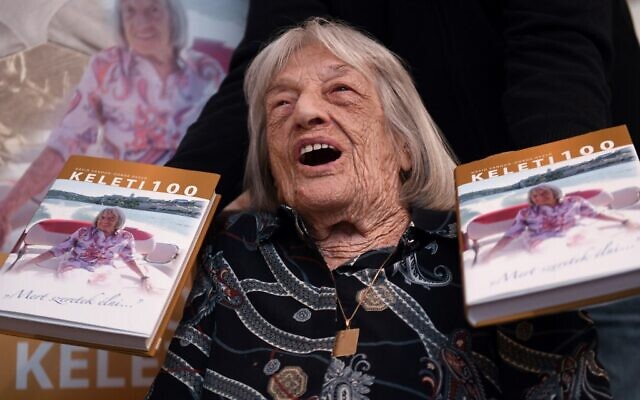 Hungarian-Israeli retired Olympic and world champion artistic gymnast Agnes Keleti with copies of her biography in her apartment in Budapest on November 6, 2020. (ATTILA KISBENEDEK / AFP) Hungarian-Israeli retired Olympic and world champion artistic gymnast Agnes Keleti with copies of her biography in her apartment in Budapest on November 6, 2020. (ATTILA KISBENEDEK / AFP)