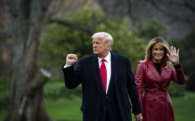 US President Donald Trump pumps his fist and First lady Melania Trump waves as they depart on the South Lawn of the White House, on December 5, 2020 in Washington, DC.(Al Drago/Getty Images/AFP)