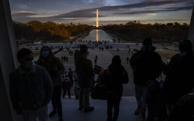 Visitors look out from the Lincoln Memorial across the Reflecting Pool at the Washington Monument as the sun sets on December 26, 2020 in Washington, DC. (Samuel Corum/Getty Images/AFP)