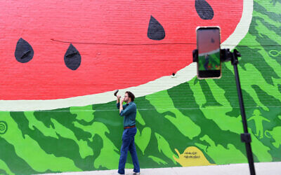 Rabbi Aaron Potek blows a shofar while recording a TikTok video in front of a watermelon mural on September 9, 2020 in Washington, DC. (Photo by Matt McClain/The Washington Post via Getty Images/ via JTA/SUE)