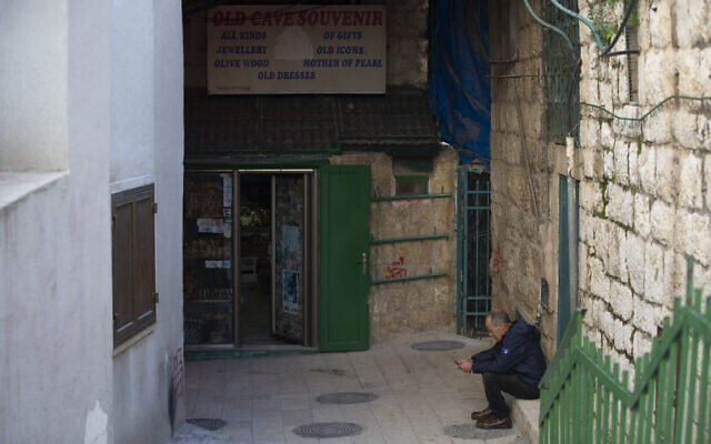 A Palestinian vendor sits in front of his shop near the Church of the Nativity, traditionally believed to be the birthplace of Jesus Christ, in the West Bank City of Bethlehem, November 23, 2020. (AP Photo/Majdi Mohammed)