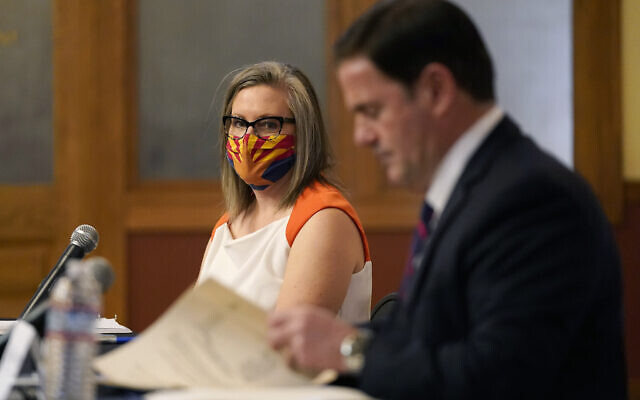 Arizona Secretary of State Katie Hobbs, left, watches as Arizona Gov. Doug Ducey signs election documents to certify the election results for federal, statewide, and legislative offices and statewide ballot measures at the official canvass at the Arizona Capitol Monday, Nov. 30, 2020, in Phoenix. (AP Photo/Ross D. Franklin, Pool) Arizona Secretary of State Katie Hobbs, left, watches as Arizona Gov. Doug Ducey signs election documents to certify the election results for federal, statewide, and legislative offices and statewide ballot measures at the official canvass at the Arizona Capitol Monday, Nov. 30, 2020, in Phoenix. (AP Photo/Ross D. Franklin, Pool)