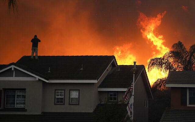 Illustrative: Herman Termeer, 54, stands on the roof of his home as the Blue Ridge Fire burns along the hillside in Chino Hills, California, October 27, 2020. (AP Photo/Jae C. Hong) Illustrative: Herman Termeer, 54, stands on the roof of his home as the Blue Ridge Fire burns along the hillside in Chino Hills, California, October 27, 2020. (AP Photo/Jae C. Hong)