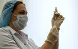 A Russian medical worker prepares a shot of Russia's Sputnik V coronavirus vaccine in Moscow, Russia, December 5, 2020. (AP Photo/Pavel Golovkin)