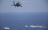 Illustrative: A US MH-60 Seahawk helicopter flies over Iranian Revolutionary Guard patrol boats in the Strait of Hormuz, December 21, 2018. (AP Photo/Jon Gambrell, File)