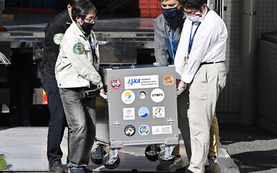 A small capsule dropped by Japan's Hayabusa2 spacecraft, concealed in a container box, arrives at the Japan Aerospace Exploration Agency's research facility in Sagamihara, near Tokyo, December 8, 2020. (Yu Nakajima/Kyodo News via AP)