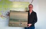 In this photo released by the police department in Duesseldorf on Thursday December 10, 2020, showing Chief Detective Michael Dietz holding a painting from French artist Yves Tanguy.  (Polizei Duesseldorf via AP)