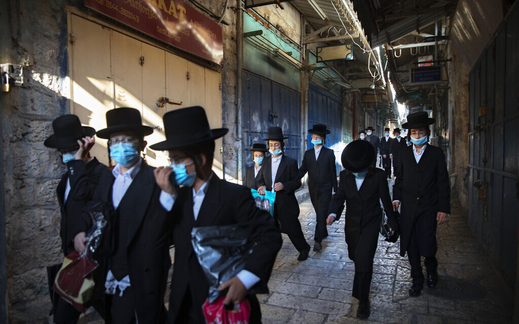 A group of ultra-Orthodox men wear protective face masks following government measures to help stop the spread of the coronavirus, as they walk in Jerusalem's Old City, July 16, 2020. (AP Photo/Oded Balilty) A group of ultra-Orthodox men wear protective face masks following government measures to help stop the spread of the coronavirus, as they walk in Jerusalem's Old City, July 16, 2020. (AP Photo/Oded Balilty)