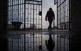 Illustrative: A man walks through the gate of the Sachsenhausen Nazi death camp with the phrase 'Arbeit macht frei' (work sets you free) in Oranienburg, Germany, on International Holocaust Remembrance Day, January 27, 2019. (Markus Schreiber/AP)