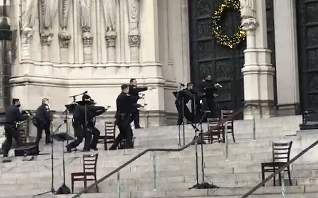 New York police officers move in on the scene of a shooting at the Cathedral Church of St. John the Divine, Sunday, Dec. 13, 2020, in New York. A man was shot by police after shots rang out at the end of a Christmas choral concert on the steps of the Manhattan cathedral Sunday afternoon. It's unclear if the gunman was killed or if any others were injured. The shooting happened just before 4 p.m. at the church which is the mother church of the Episcopal Diocese of New York and seat of its bishop. (AP Photo/Ted Shaffrey) New York police officers move in on the scene of a shooting at the Cathedral Church of St. John the Divine, Sunday, Dec. 13, 2020, in New York. A man was shot by police after shots rang out at the end of a Christmas choral concert on the steps of the Manhattan cathedral Sunday afternoon. It's unclear if the gunman was killed or if any others were injured. The shooting happened just before 4 p.m. at the church which is the mother church of the Episcopal Diocese of New York and seat of its bishop. (AP Photo/Ted Shaffrey)
