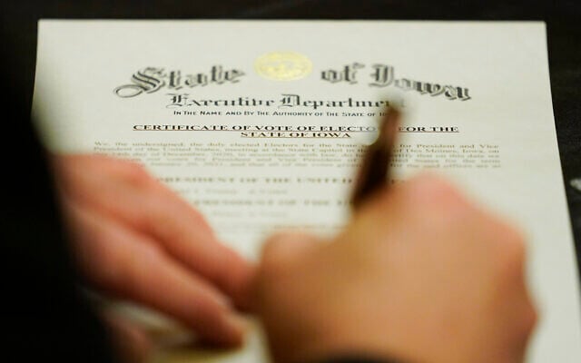 A member of Iowa's Electoral College signs the Certificate of Vote of Electors for the State of Iowa, December 14, 2020, at the Statehouse in Des Moines, Iowa. (AP Photo/Charlie Neibergall) A member of Iowa's Electoral College signs the Certificate of Vote of Electors for the State of Iowa, December 14, 2020, at the Statehouse in Des Moines, Iowa. (AP Photo/Charlie Neibergall)