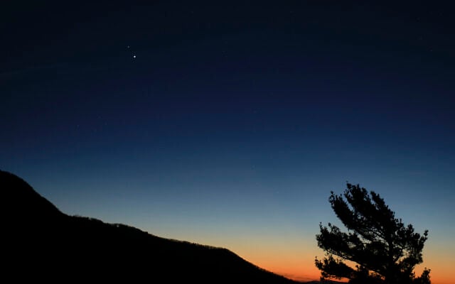 In this December 13, 2020, photo made available by NASA, Saturn, top, and Jupiter, below, are seen after sunset from Shenandoah National Park in Luray, Virginia. (Bill Ingalls/NASA via AP) In this December 13, 2020, photo made available by NASA, Saturn, top, and Jupiter, below, are seen after sunset from Shenandoah National Park in Luray, Virginia. (Bill Ingalls/NASA via AP)