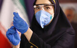 A medic prepares the Coviran coronavirus vaccine produced by Shifa Pharmed, part of a state-owned pharmaceutical conglomerate, for injection at a ceremony in Tehran, Iran, December 29, 2020. (AP Photo/Aref Taherkenareh)