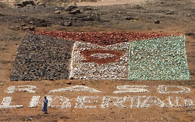 A woman supporting pro-independence Polisario Front rebel soldiers walks near a makeshift Western Sahara flag of painted stones reading: 'Saharawi Arab Democratic Republic, or SADR, free' in the desert near Tifariti, May 20, 2008. (Daniel Ochoa de Olza/AP) A woman supporting pro-independence Polisario Front rebel soldiers walks near a makeshift Western Sahara flag of painted stones reading: 'Saharawi Arab Democratic Republic, or SADR, free' in the desert near Tifariti, May 20, 2008. (Daniel Ochoa de Olza/AP)