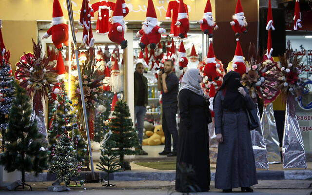 File: Palestinians walk past a shop selling Christmas decorations and ornaments in Gaza City, Wednesday, Dec. 18, 2019 (AP Photo/Hatem Moussa) File: Palestinians walk past a shop selling Christmas decorations and ornaments in Gaza City, Wednesday, Dec. 18, 2019 (AP Photo/Hatem Moussa)