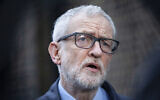 Former Britain's Labour party leader Jeremy Corbyn speaks to the media on the coronavirus, outside the Finsbury Park Jobcentre, in north London, March 15, 2020. (Hollie Adams/PA via AP)