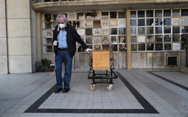 A man pays respects near the coffin of his wife who was 75-years-old, during a funeral ceremony under the care of Paris undertaker Franck Vasseur, at Pere Lachaise cemetery in Paris, April 24, 2020 (AP Photo/Francois Mori) A man pays respects near the coffin of his wife who was 75-years-old, during a funeral ceremony under the care of Paris undertaker Franck Vasseur, at Pere Lachaise cemetery in Paris, April 24, 2020 (AP Photo/Francois Mori)