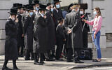 Members of ultra-Orthodox community gather to listen to an interview conducted by a journalist on a street corner, in the Borough Park neighborhood of New York as Gov. Andrew Cuomo moved to reinstate restrictions on houses of worship in and near areas where coronavirus cases are spiking, October 7, 2020. (John Minchillo/AP)