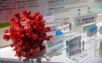 A model of a coronavirus is displayed next to boxes for COVID-19 vaccines at an exhibit by Chinese pharmaceutical firm Sinopharm at the China International Fair for Trade in Services (CIFTIS) in Beijing, September 5, 2020. (Mark Schiefelbein/AP)