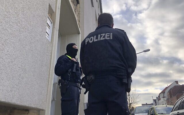 Illustrative: Police officers stand outside an apartment building during a search in Osnabrueck, Germany, November 6, 2020. (Festim Beqiri/TV7News/dpa via AP)