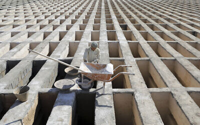 A cemetery worker prepares new graves at the Behesht-e-Zahra cemetery on the outskirts of the Iranian capital, Tehran, Iran, November 1, 2020. (Ebrahim Noroozi/AP)
