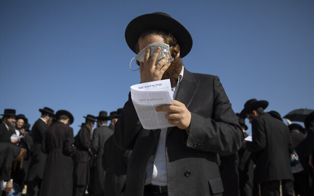 An ultra-Orthodox Jewish man covers his eyes with a face mask in Jerusalem, November 18, 2020. (AP/Oded Balilty) An ultra-Orthodox Jewish man covers his eyes with a face mask in Jerusalem, November 18, 2020. (AP/Oded Balilty)