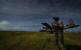 A junior sniper, assigned to the 1-186th Infantry Battalion, Task Force Guardian, Combined Joint Task Force - Horn of Africa, provides security for a 75th Expeditionary Airlift Squadron (EAS) C-130J Super Hercules during unloading operations at an unidentified location in Somalia June 28, 2020 (Tech. Sgt. Christopher Ruano/Combined Joint Task Force - Horn of Africa via AP)